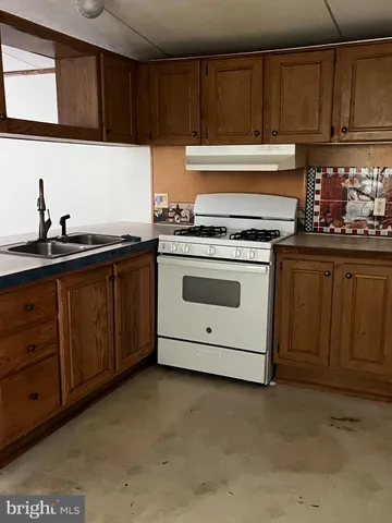 a kitchen with granite countertop a stove sink and cabinets