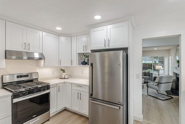 a kitchen with stainless steel appliances a refrigerator sink and stove