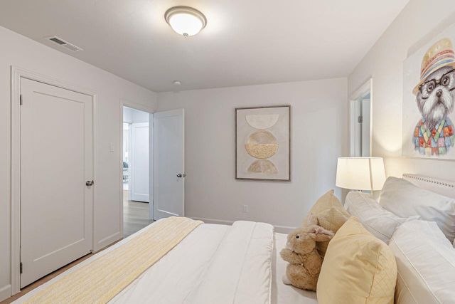 a bedroom with a bed and a painting on the wall