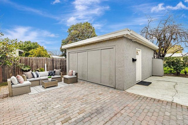 a view of a patio with couches and table and chairs and potted plants