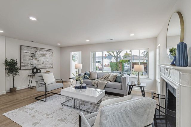a living room with furniture a fireplace and a floor to ceiling window