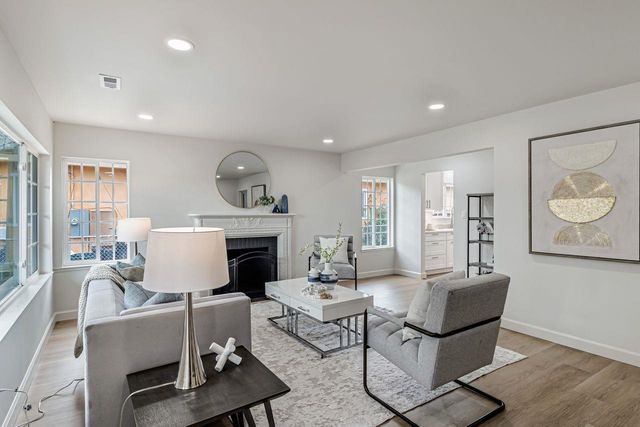 a living room with furniture a fireplace and a large window