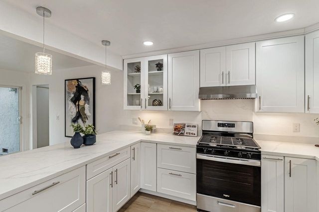 a kitchen with white cabinets and appliances
