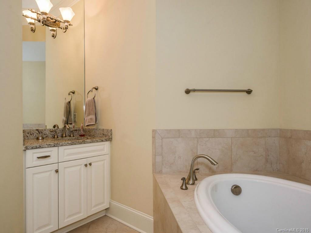 2823 Providence Road, Unit 145 Charlotte, NC 28211 - Photo 11 of 24 a bathroom with a granite countertop sink a mirror and a bathtub