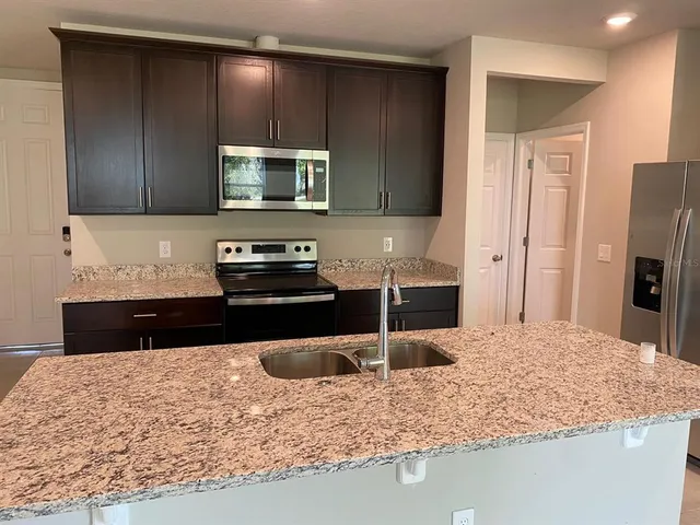 a kitchen with a refrigerator sink and stove
