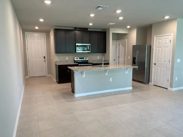 a kitchen with stainless steel appliances granite countertop a refrigerator stove microwave and cabinets