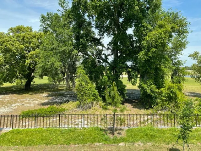 a front view of a house with yard and parking