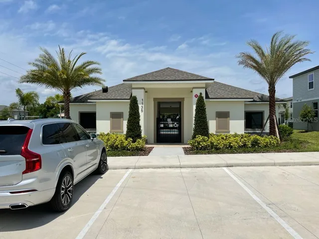 a front view of house with yard and car parked