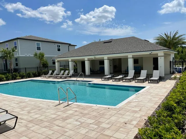 a sign board with tall buildings in the background