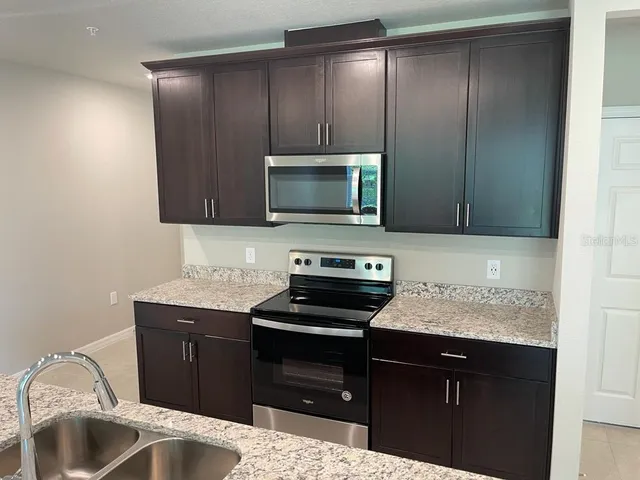 a kitchen with a sink and a stove top oven