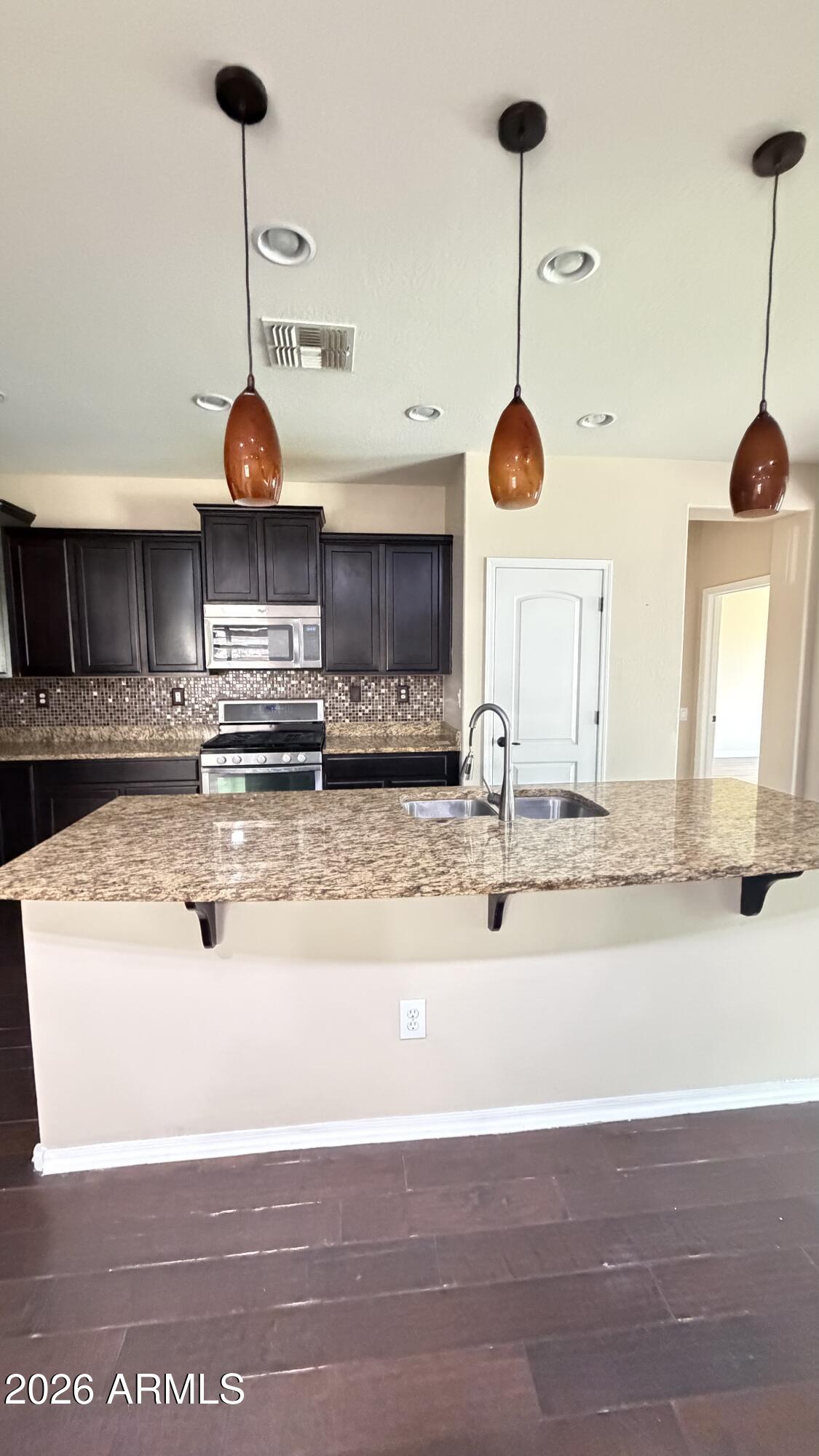 10786 West Yearling Road Peoria, AZ 85383 - Photo 9 of 21 a kitchen with stainless steel appliances granite countertop a sink a stove and a wooden floors