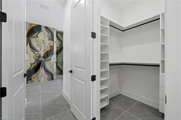 a view of walk in closet with clothes and shoes