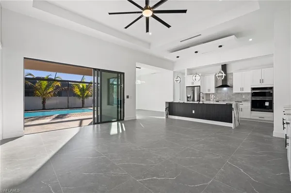 a view of an empty room with window and a ceiling fan