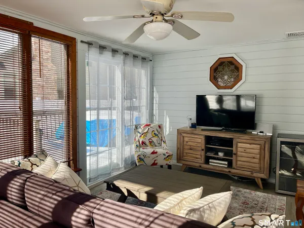 a bedroom with a bed a television and a large window
