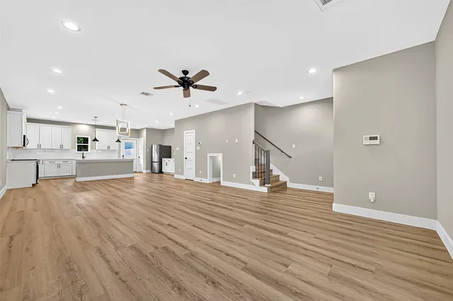 a view of empty room with wooden floor and window