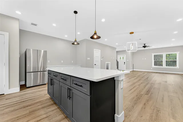 a kitchen with kitchen island a sink appliances and wooden floor