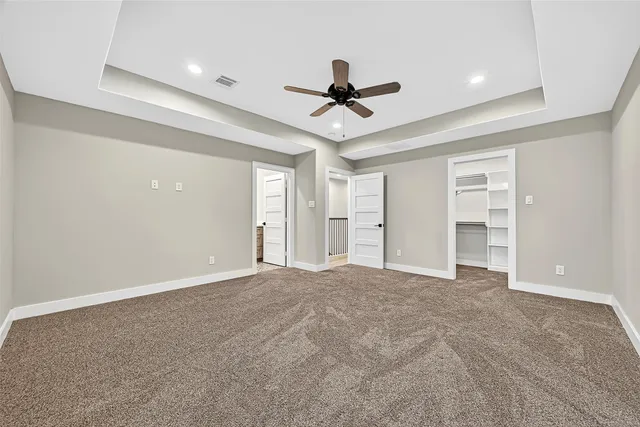 a view of empty room with wooden floor and ceiling fan