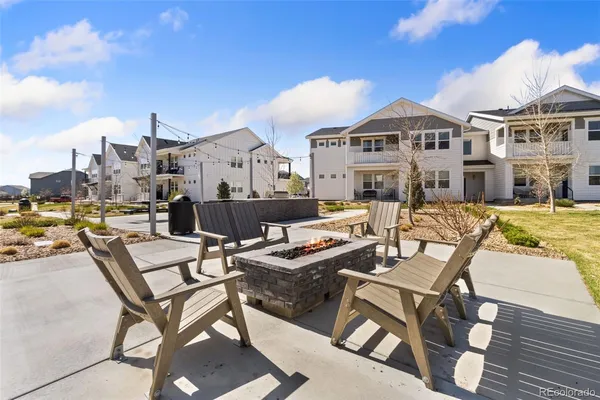 a kitchen with stainless steel appliances a table chairs refrigerator and a microwave