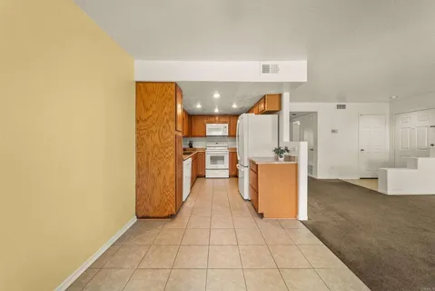 a view of a kitchen with refrigerator and wooden floor