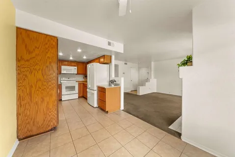 a view of a kitchen with furniture and an empty room