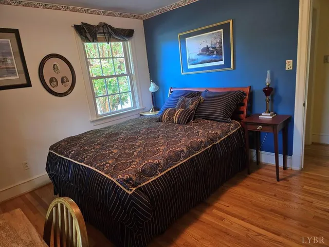 a bed sitting in a bedroom next to a window with a bookshelf and a bookshelf