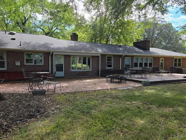 a backyard of a house with yard table and chairs