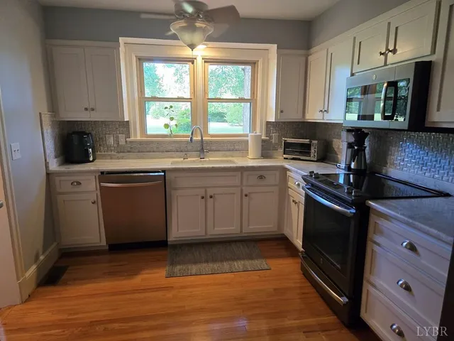 a kitchen with stainless steel appliances granite countertop a stove a sink dishwasher and a microwave