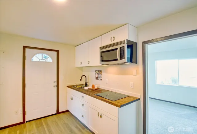 a kitchen with granite countertop white cabinets and stainless steel appliances