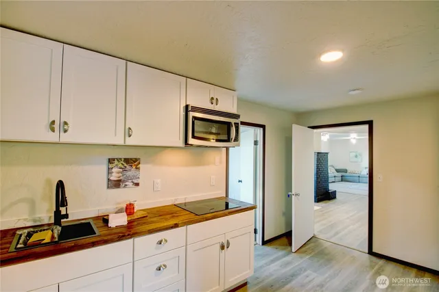a view of a refrigerator in kitchen and an empty room
