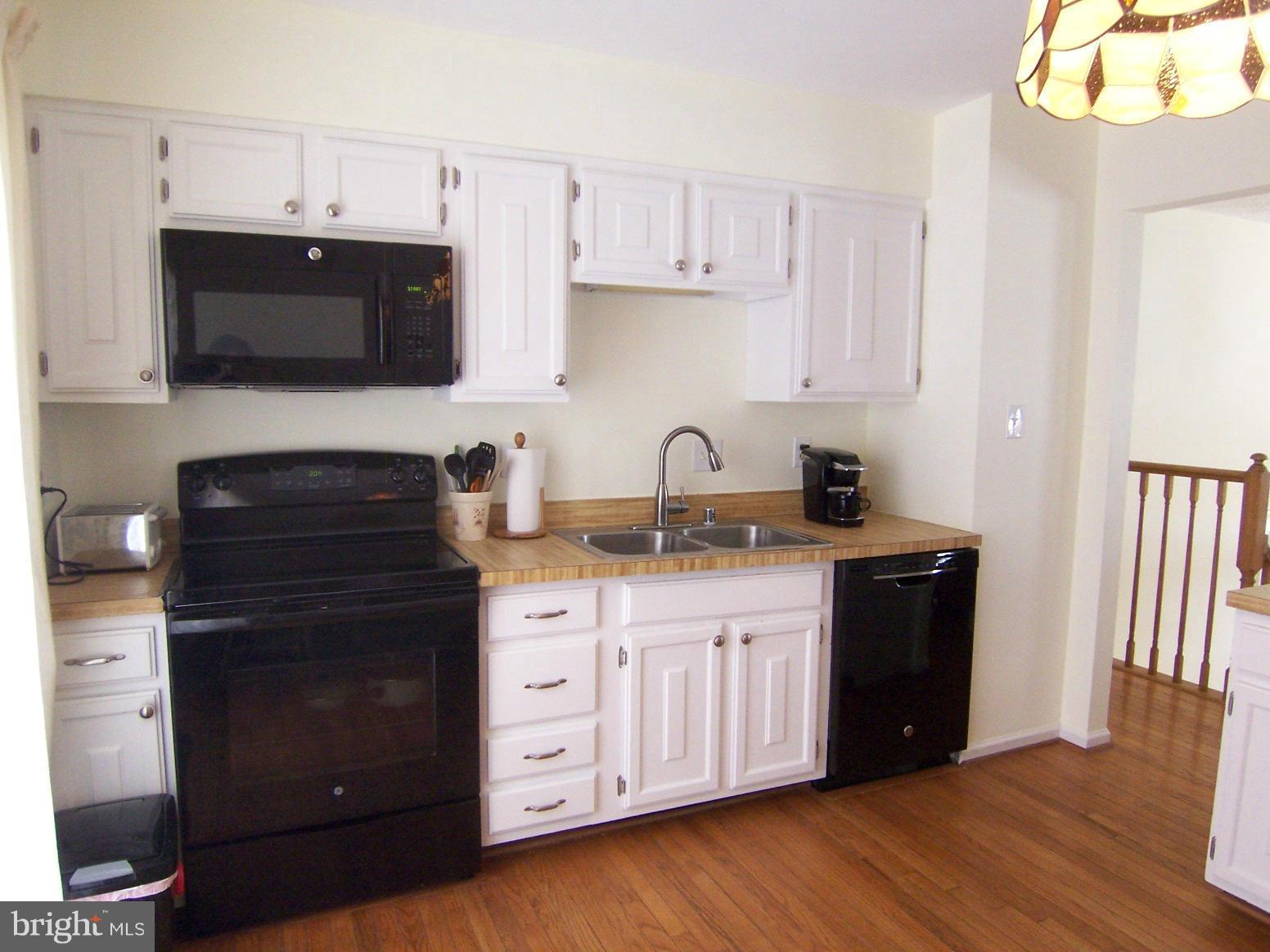 9104 Rookings Court Springfield, VA 22153 - Photo 8 of 22 a kitchen with stainless steel appliances granite countertop a stove a sink and a microwave