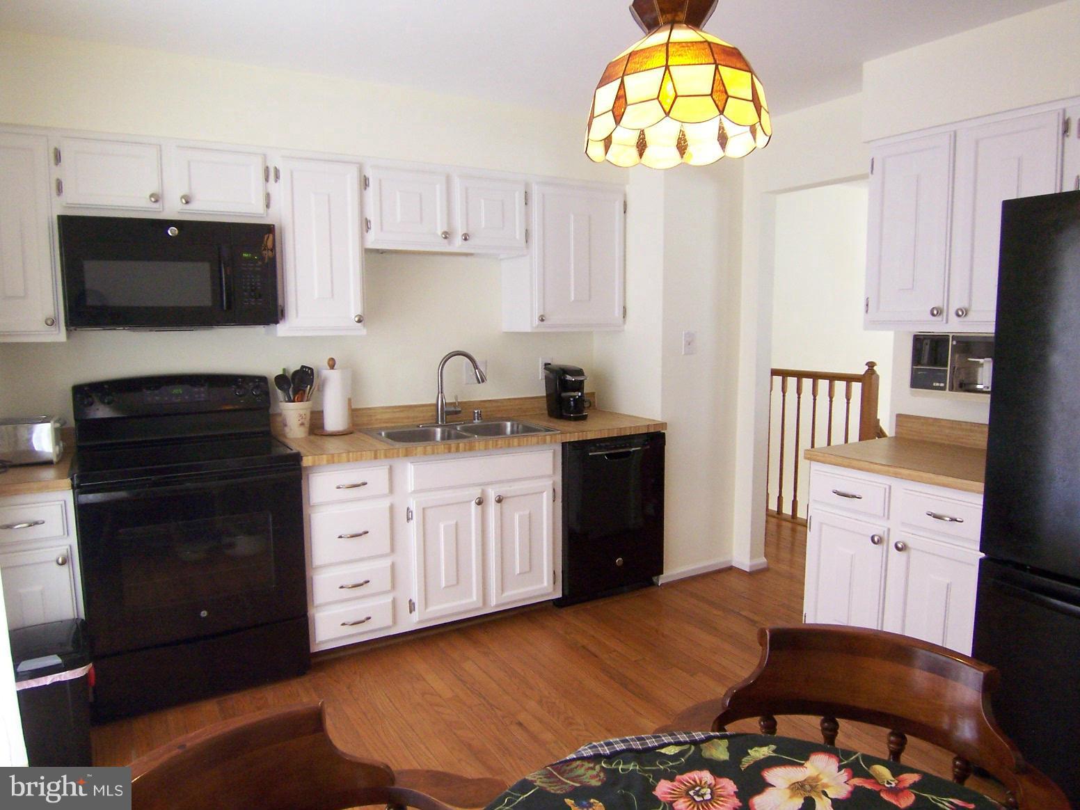 9104 Rookings Court Springfield, VA 22153 - Photo 9 of 22 a kitchen with stainless steel appliances granite countertop a sink dishwasher a stove and a refrigerator with wooden floor