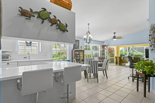 a kitchen with kitchen island granite countertop a stove a sink dishwasher and white cabinets with wooden floor