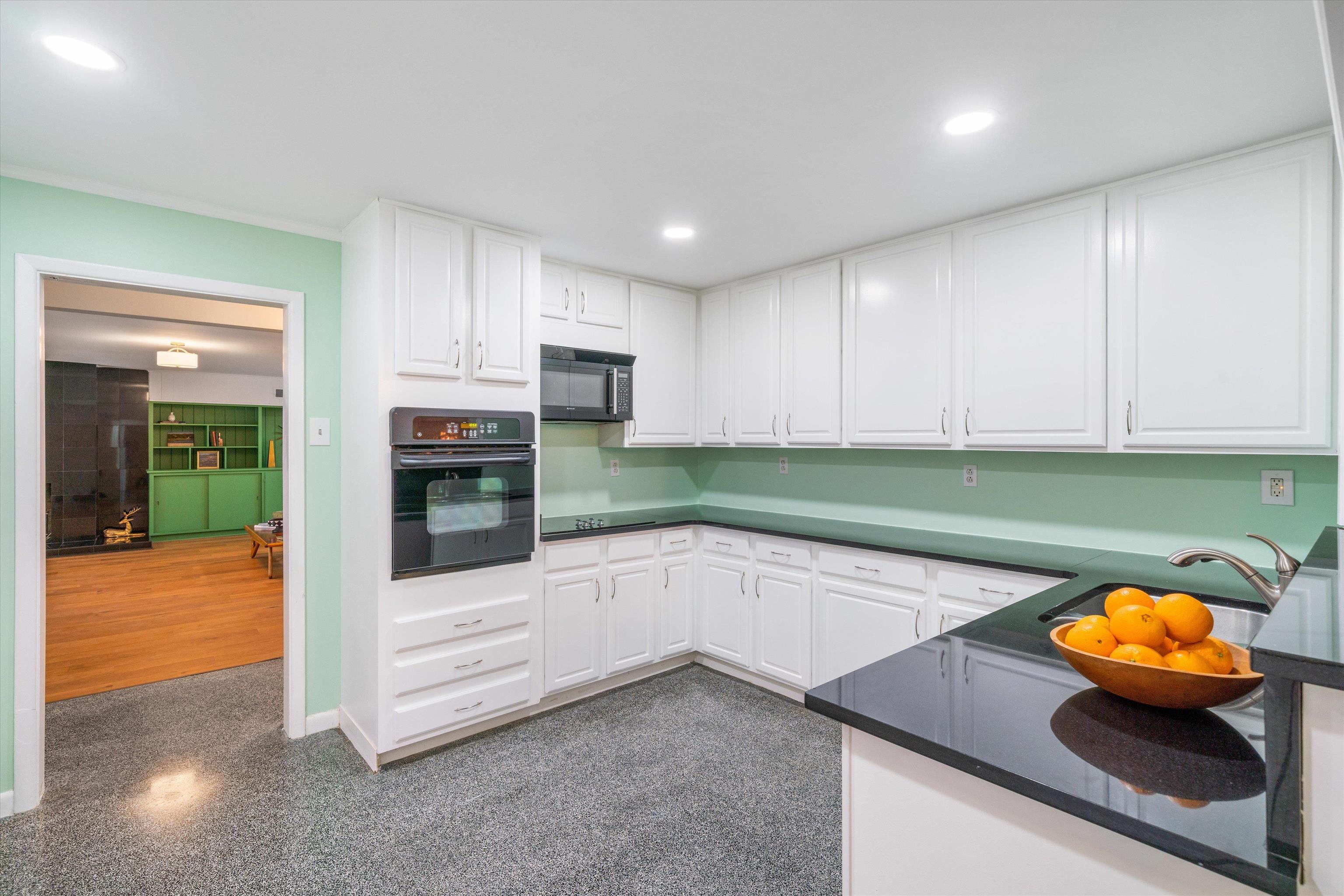 5420 Walnut Grove Road Memphis, TN 38120 - Photo 11 of 25 a kitchen with stainless steel appliances a sink a stove a microwave a sink and white cabinets