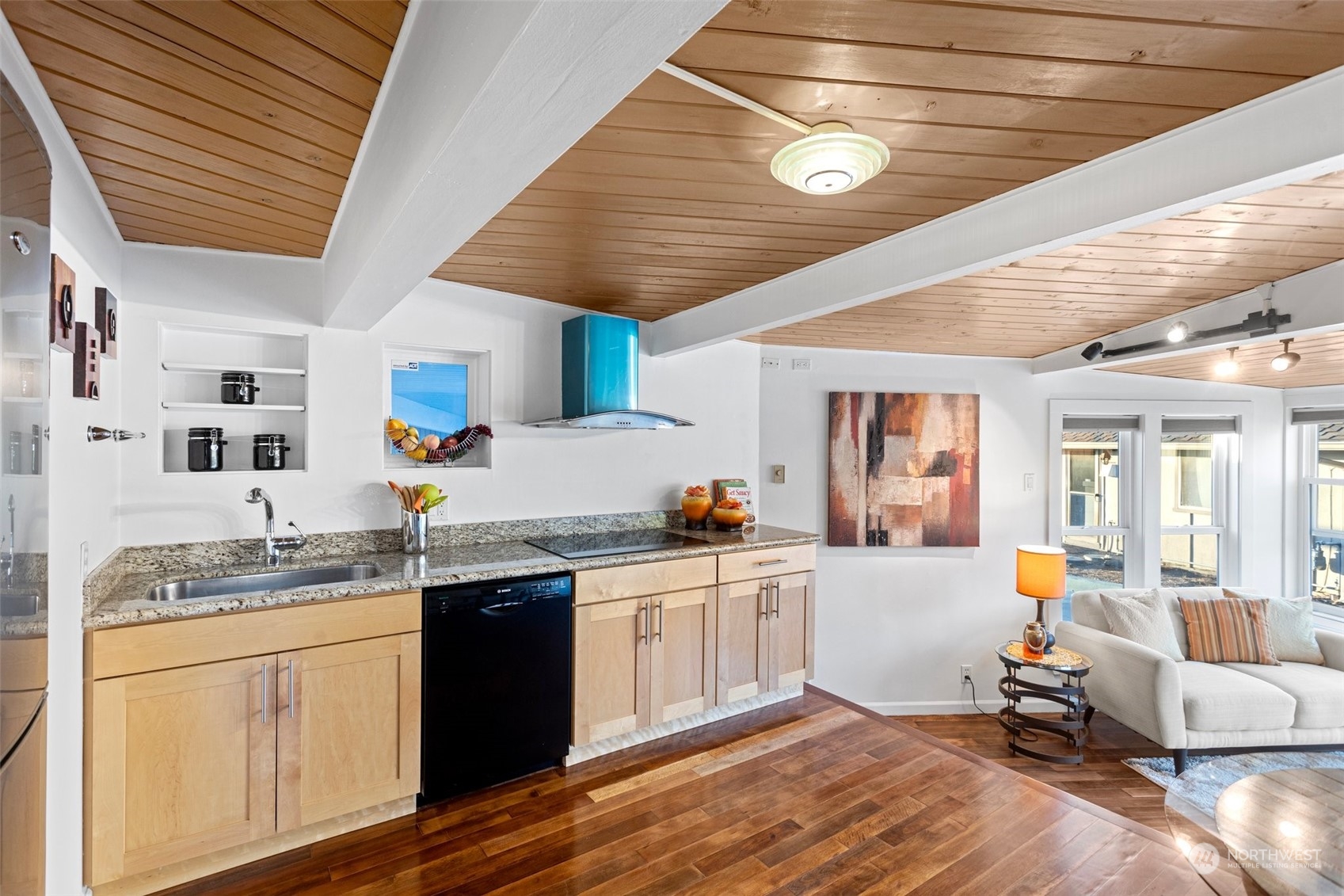 4428 140th Avenue Southeast Bellevue, WA 98006 - Photo 32 of 40 a kitchen with a sink dishwasher a stove a dining table and chairs with wooden floor