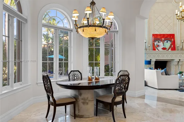 a view of a backyard with couches table and chairs under an umbrella
