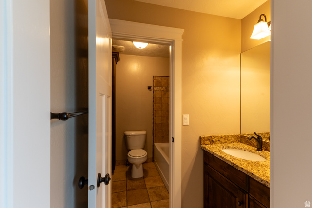 3565 West 1350th Street North Vernal, UT 84078 - Photo 30 of 54 Bathroom featuring a wood-finish vanity with a stone countertop, an integrated sink, and an oil-rubbed bronze faucet