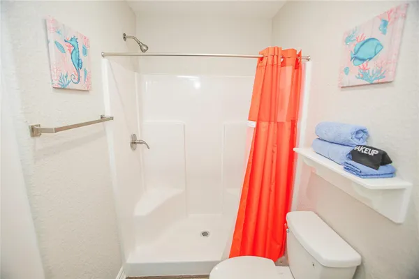 a bathroom with a toilet and a shower