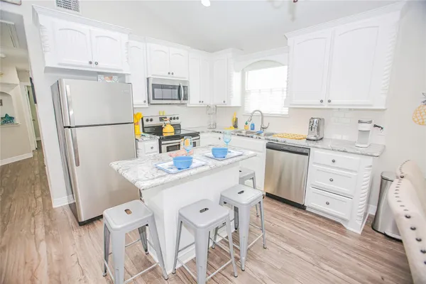 a kitchen with white cabinets and white appliances