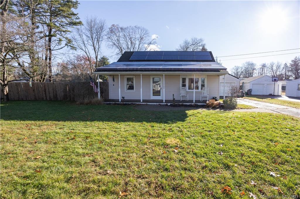 a view of a house with a yard and sitting area