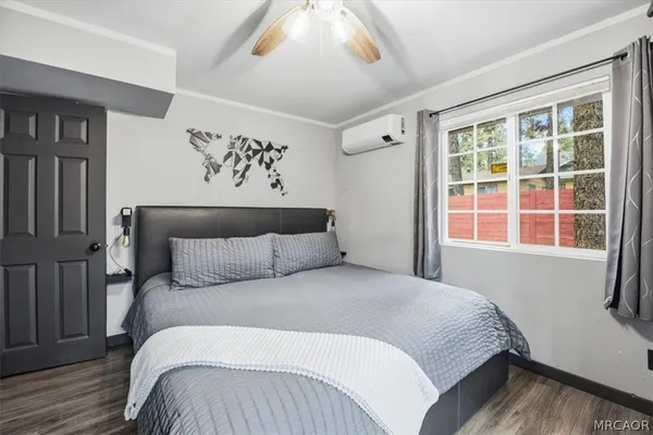 a bedroom with a bed and painting on the wall