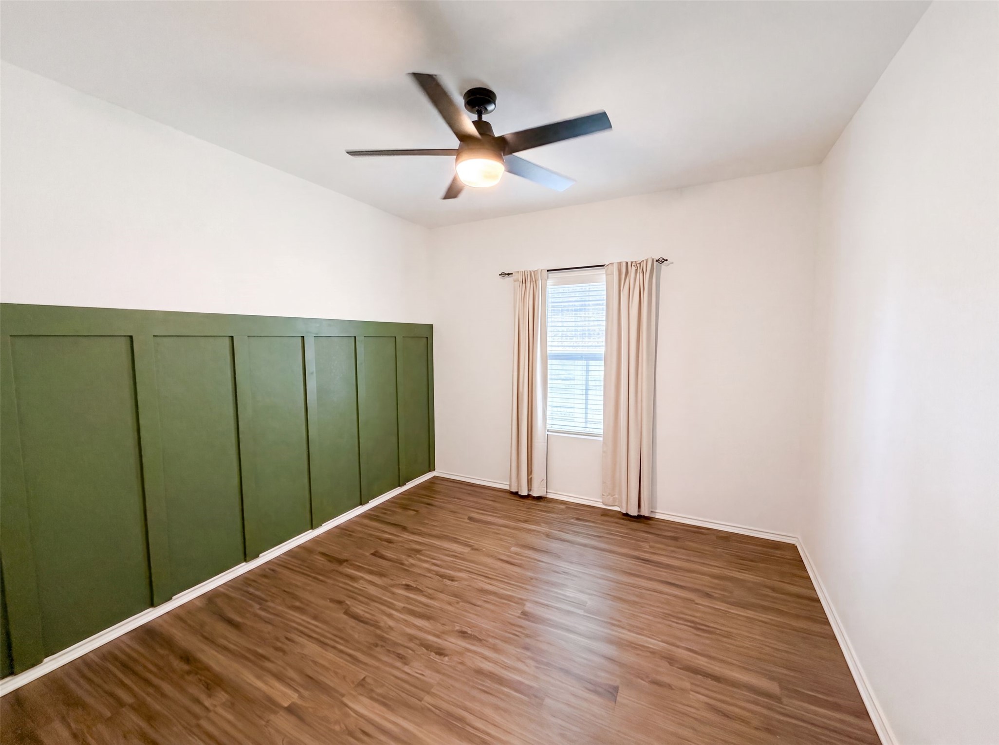 424 Wolf Springs Road Georgetown, TX 78628 - Photo 9 of 15 Wood flooring and a decorative green accent wall define this well-lit room.