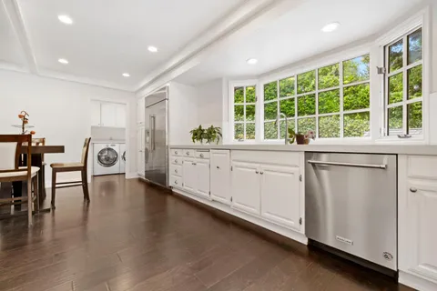 a living room with furniture a flat screen tv and floor to ceiling window