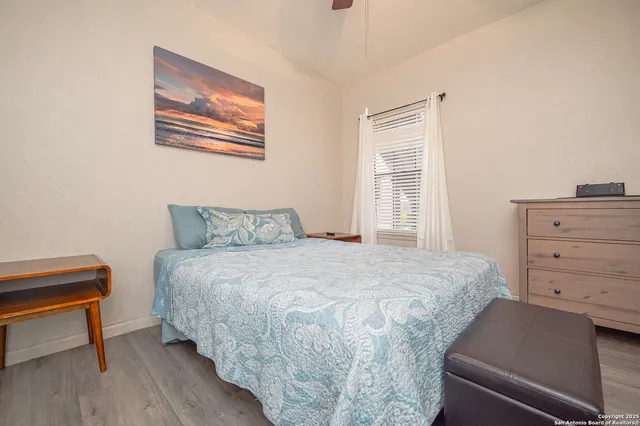 a bedroom with a bed and a lamp on dresser