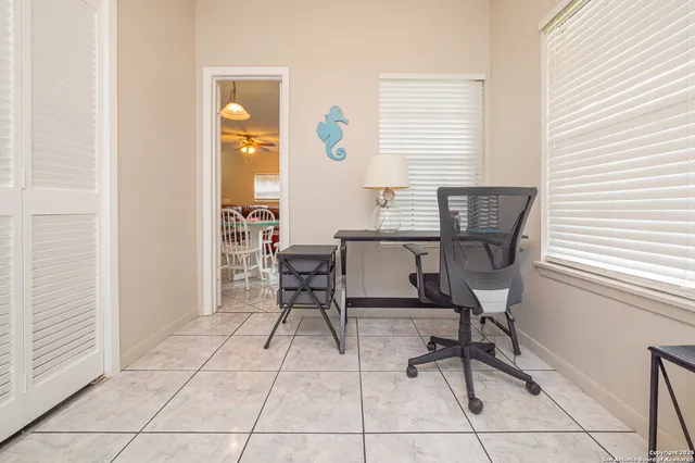 a view of a workspace with furniture and a window