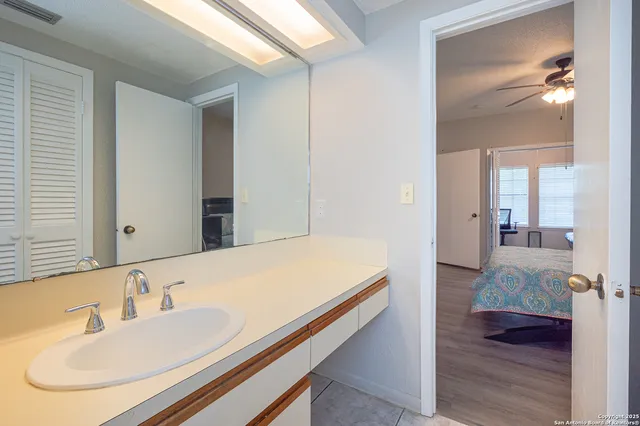 a en suite bathroom with a granite countertop sink and a mirror