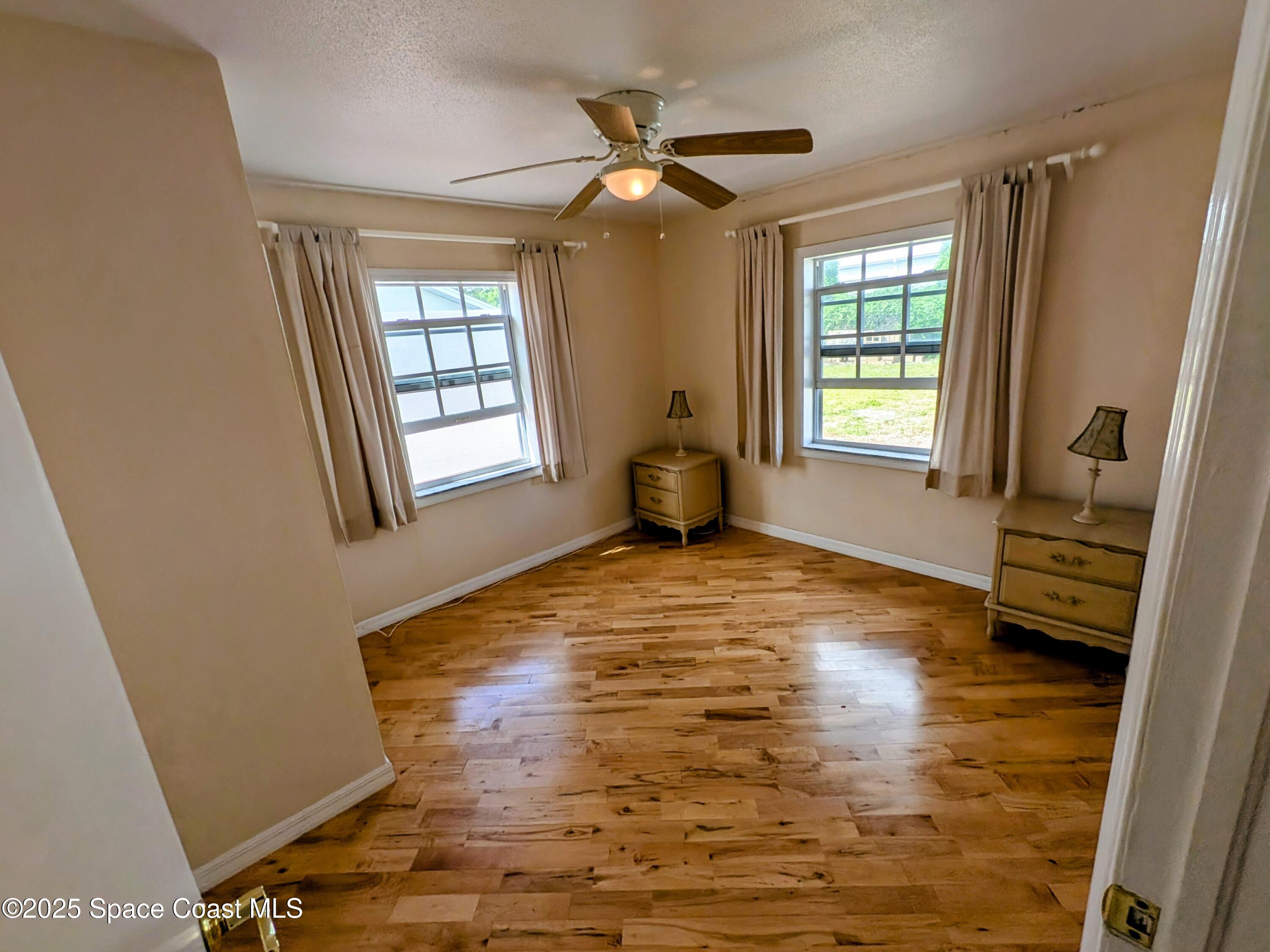 2767 Palm Drive Palm Bay, FL 32905 - Photo 11 of 26 a view of livingroom with hardwood floor and a ceiling fan