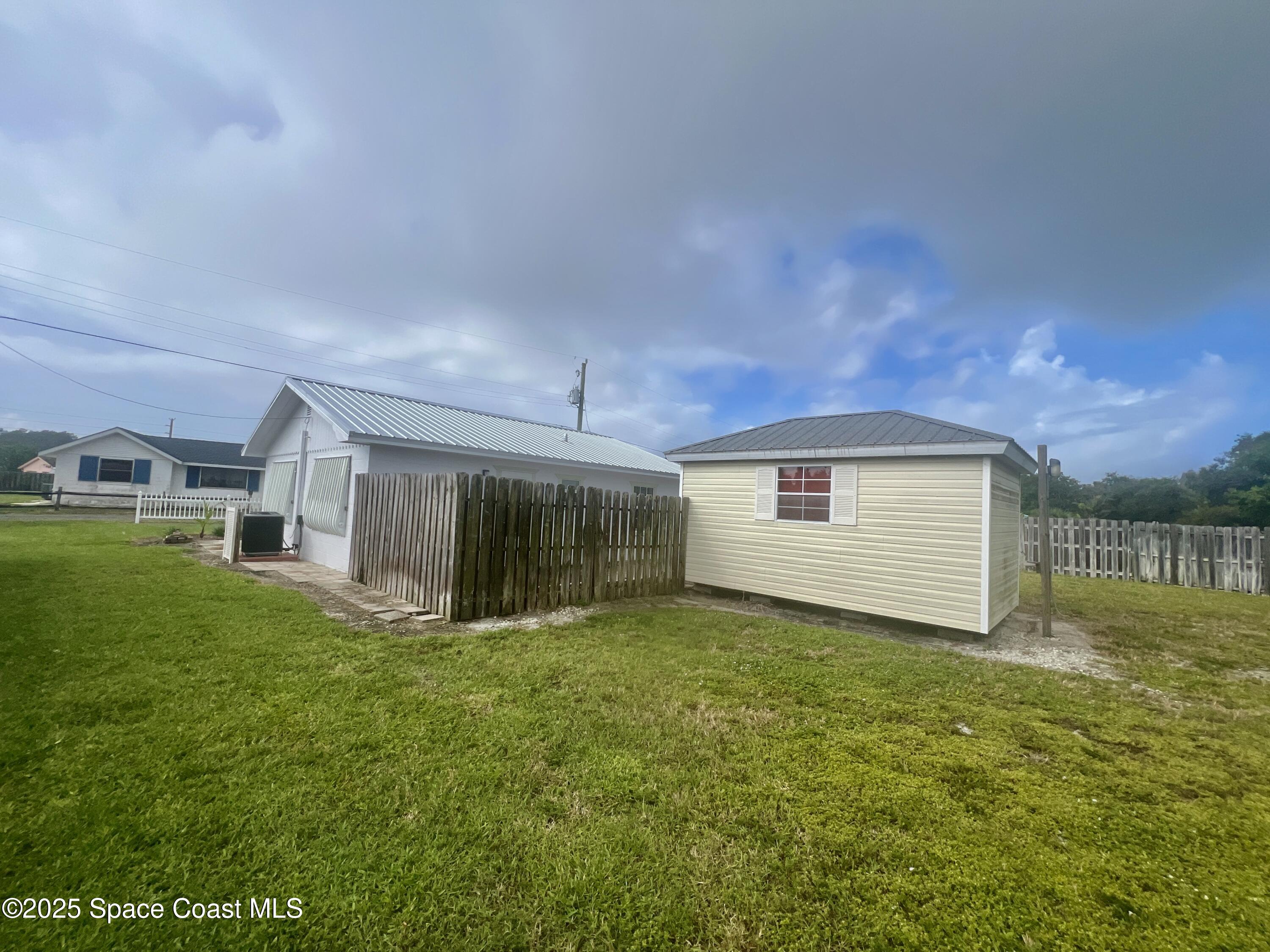2767 Palm Drive Palm Bay, FL 32905 - Photo 20 of 26 a view of a house with a yard
