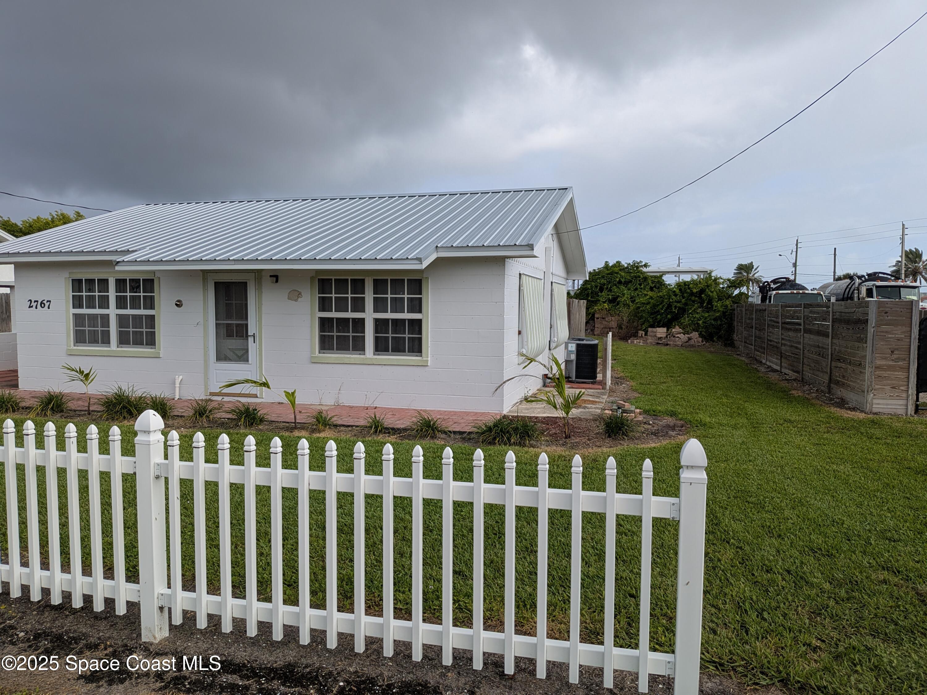 2767 Palm Drive Palm Bay, FL 32905 - Photo 2 of 26 a front view of a house with a garden