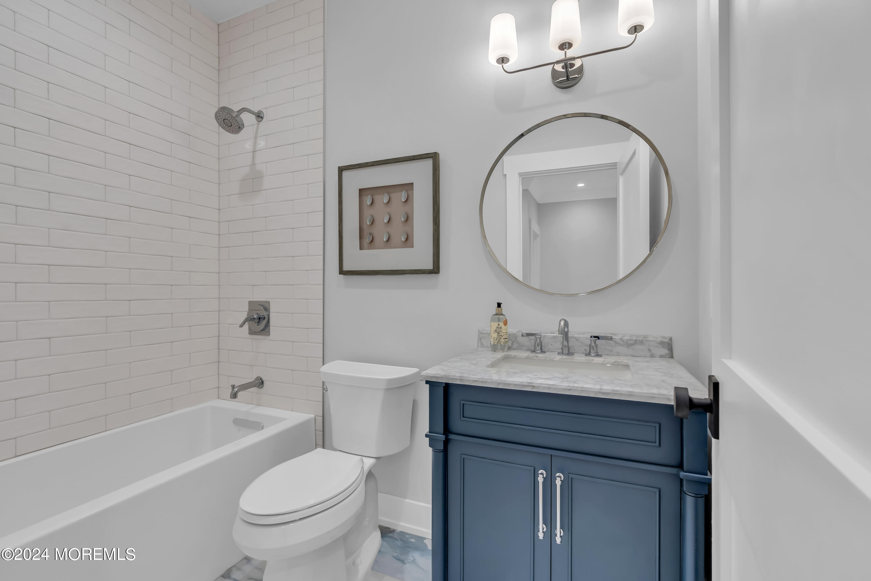 557 Ocean Road Spring Lake Heights, NJ 07762 - Photo 33 of 62 a bathroom with a toilet sink vanity tub and mirror
