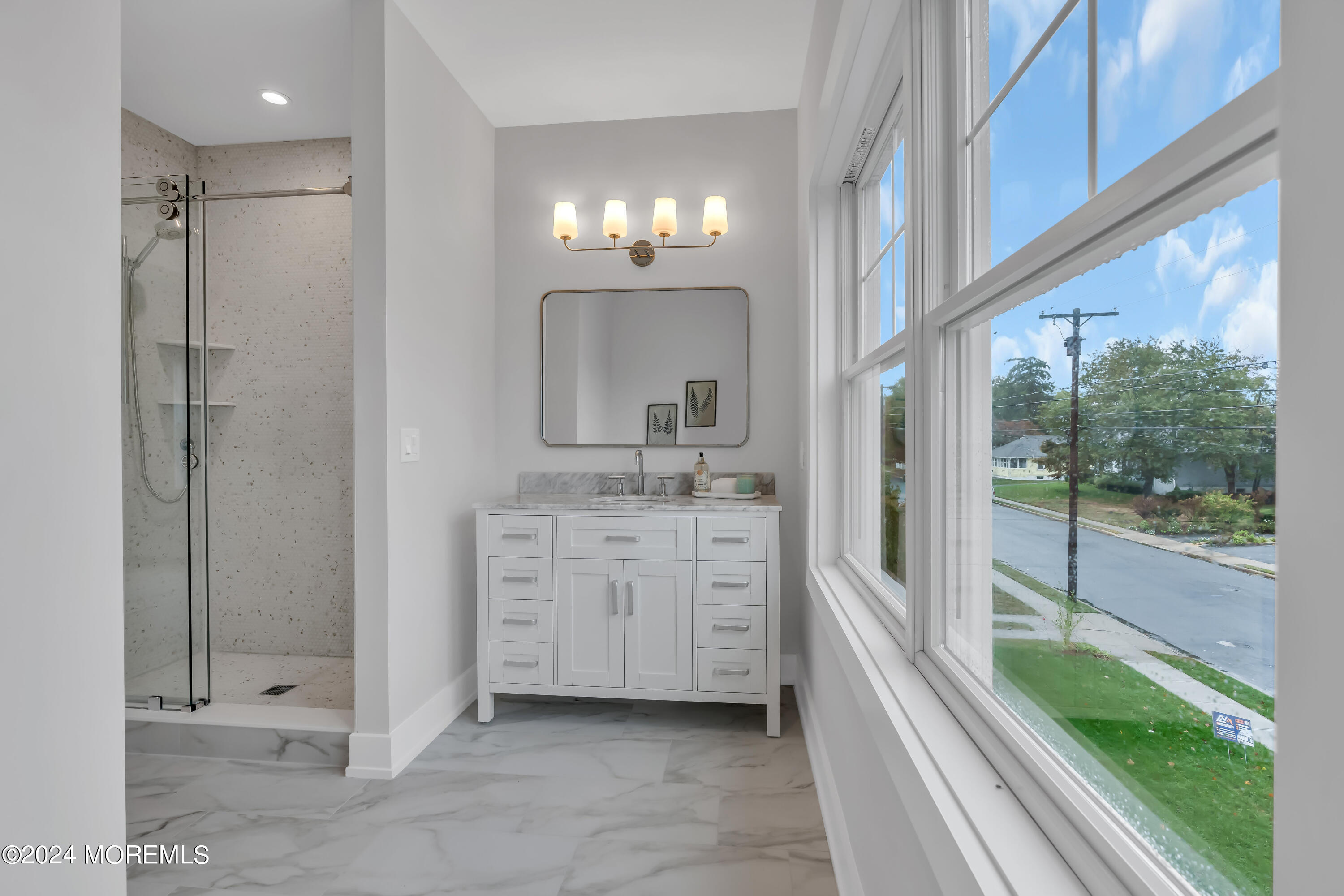 557 Ocean Road Spring Lake Heights, NJ 07762 - Photo 40 of 62 a bathroom with a shower sink and mirror